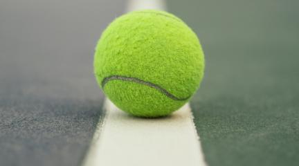 Tennis ball close up on white court line