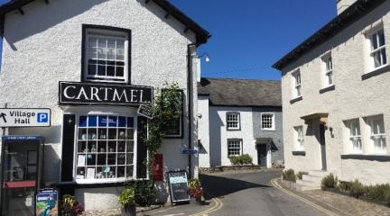 A shop in Cartmel with a road going past it into the distance.