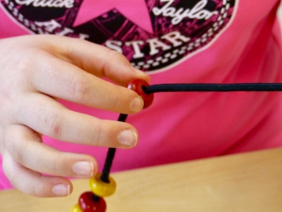 Child threading beads