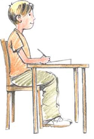 boy sitting at a desk and writing