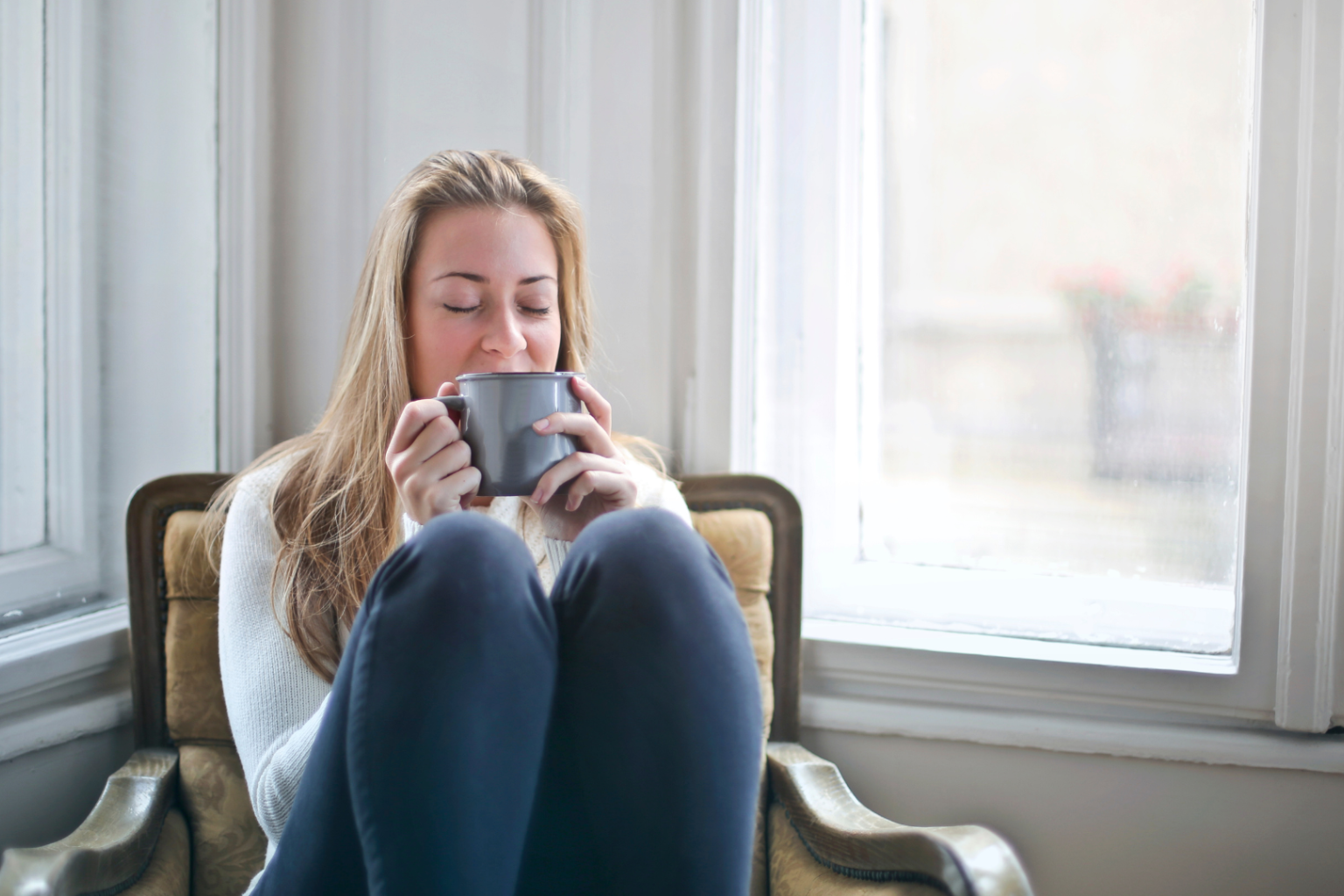 Woman sitting in a chair and drinking tea