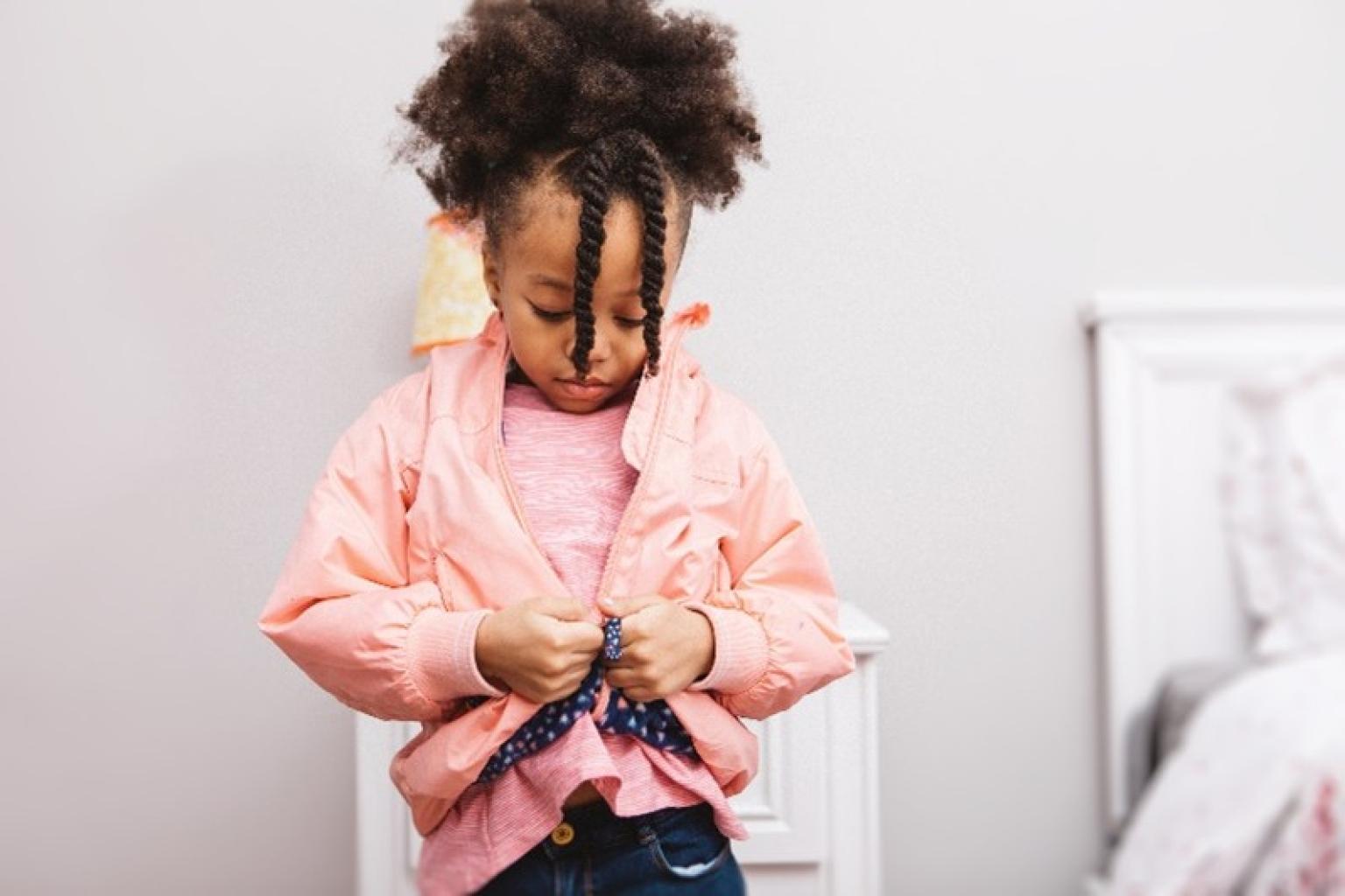 Child buttoning shirt