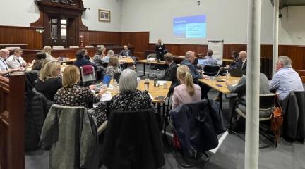 Steph Cordon showing slides to people in a meeting