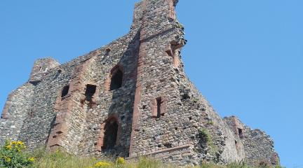 Looking up from the shore at a partly fallen-down castle wall on Piel Island