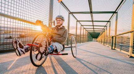 Man crossing a bridge riding an adapted bike