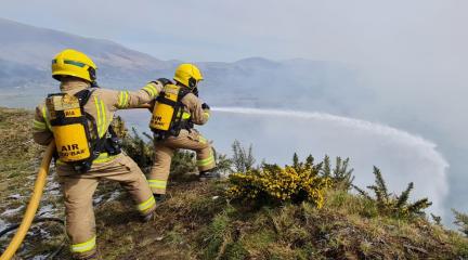 Two fireman using a hose