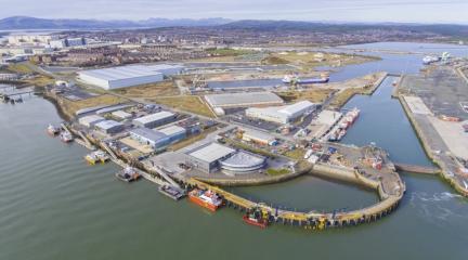 An overhead view of the Port of Barrow, with the docks in the foreground and the town and fells in the background