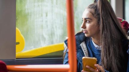 A female school student looking out of the window of a bus