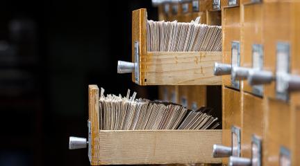 Archive records in open wooden drawers.
