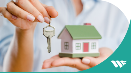 Person holding keys and a small building