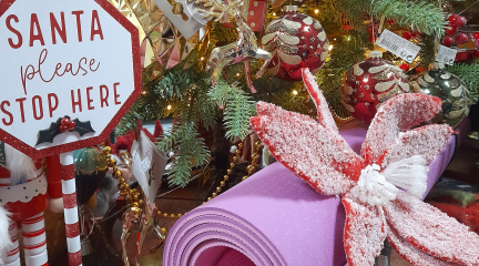 A yoga mat beside a Christmas tree