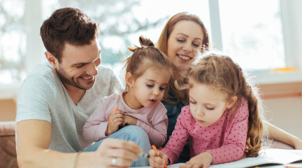 Dad, mum and two daughters drawing at the table