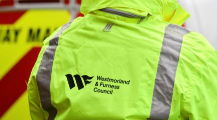 Person wearing a hi-vis jacket with Westmorland and Furness Council logo