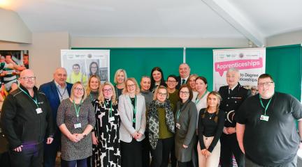 A group shot of apprentices with senior leaders at celebration event.