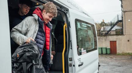 School boy stepping off bus