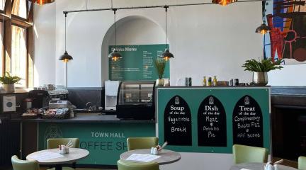 View of the new coffee shop in Barrow Town Hall showing tables, chairs and counter area
