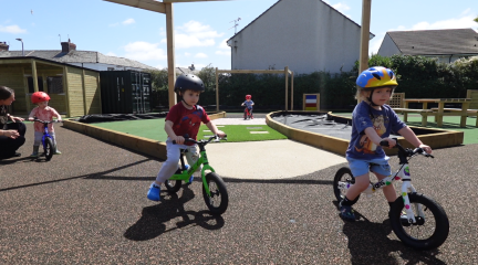 Children riding balance bikes on the new sensory trail