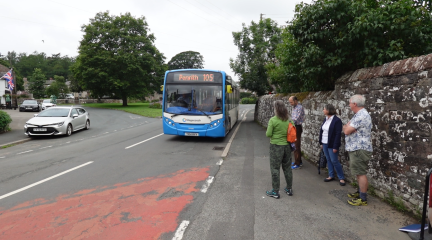 Bus arrives in Greystoke as passengers wait at the bus stop