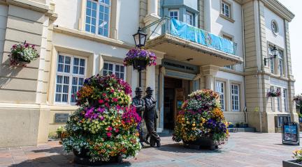 The Lauren and Hardy statue outside the Coro surrounding by bright flowers