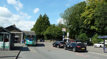 A bus at the bus stop and taxis at the taxi rank at Windermere train station.
