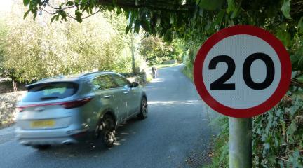 A car driving past a 20mph sign.
