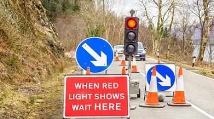 Cars waiting at traffic lights at roadworks.