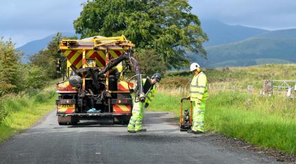 Two council workers fixing a pothole.