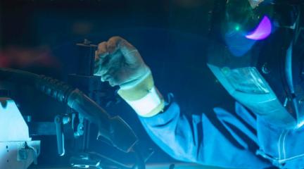 A person in a welding mask welding.