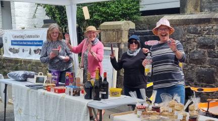Several women volunteers at a stall at a community fete.