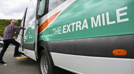 A man stepping on to a minibus.