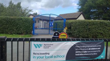 Front of Herron Hill school with a school maintenance banner