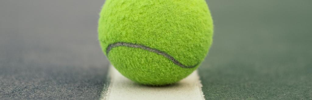 Tennis ball close up on white court line