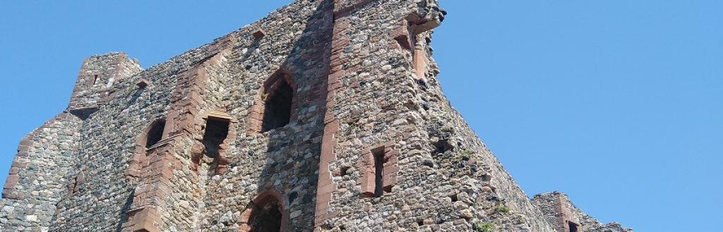 Looking up from the shore at a partly fallen-down castle wall on Peil Island