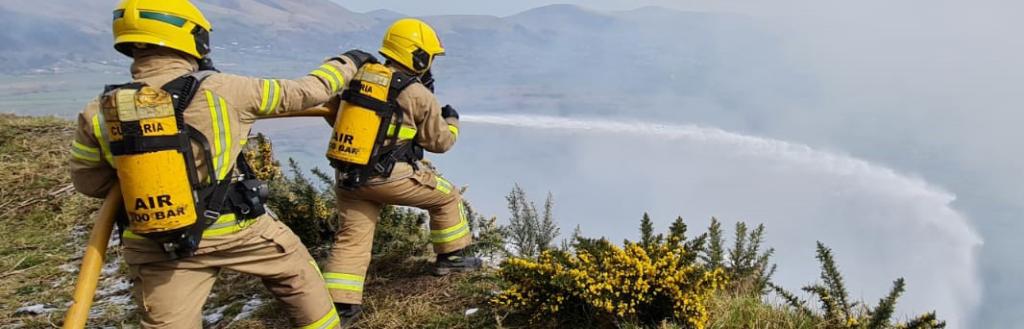 Two fireman using a hose