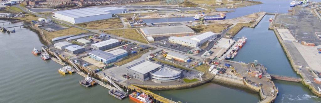 An overhead view of the Port of Barrow, with the docks in the foreground and the town and fells in the background