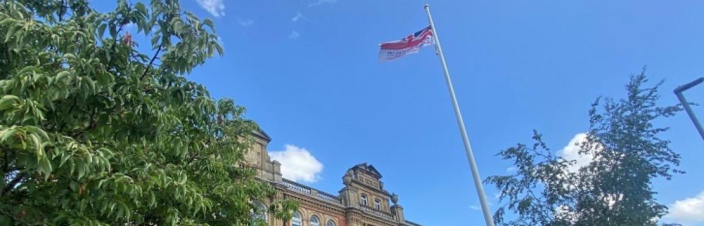 A flag flying from the top of a flagpole on front of Penrith Town Hall