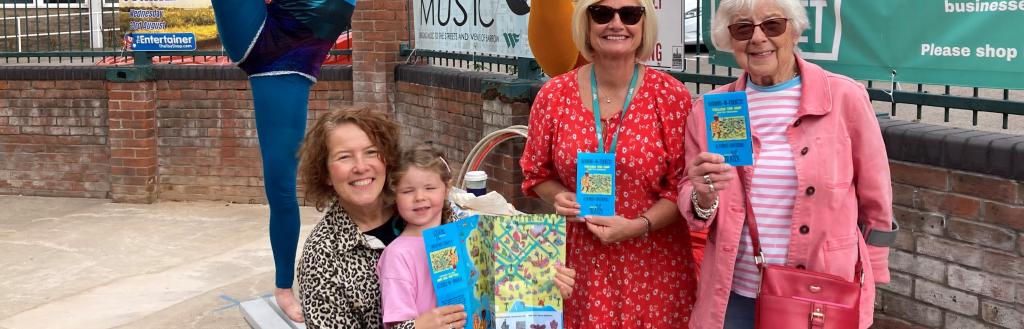 Three women and a young girl holding copies of the new Barrow Treasure Map Trail.