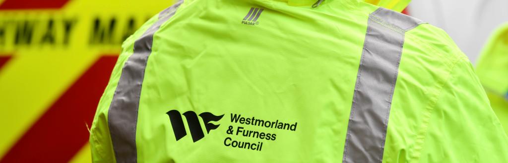Person wearing a hi-vis jacket with Westmorland and Furness Council logo