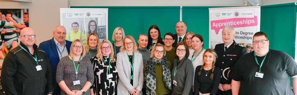 A group shot of apprentices with senior leaders at celebration event.