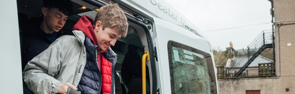 School boy stepping off bus