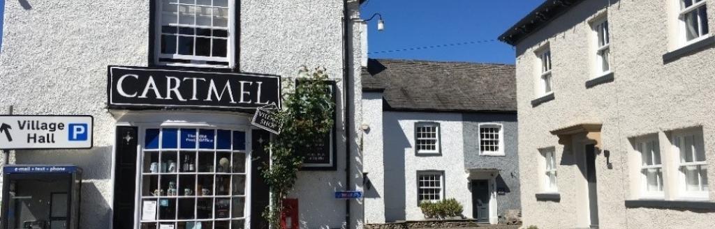 A shop in Cartmel with a road going past it into the distance.