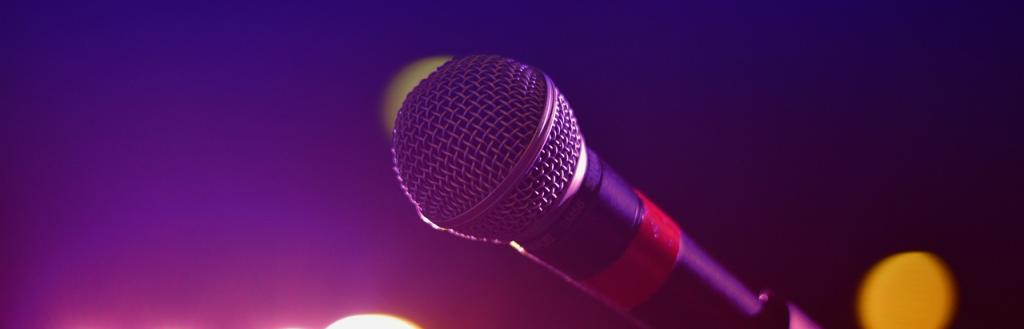 A microphone with stage lights in the background.