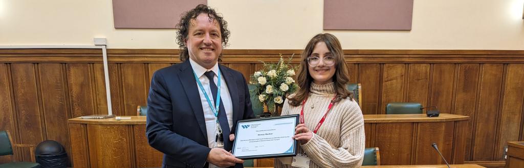 New member of youth parliament Honey Barker receives a certificate from director of children's services, Milorad Vasic