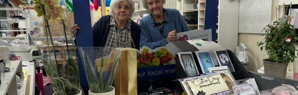 Two women standing in a market stall.