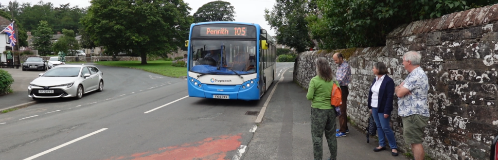 Bus arrives in Greystoke as passengers wait at the bus stop