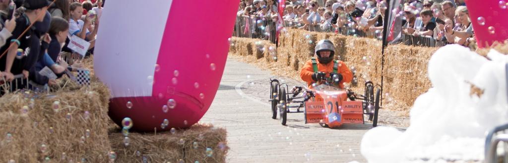 A kart going dowm the ramp at a soaabox derby.