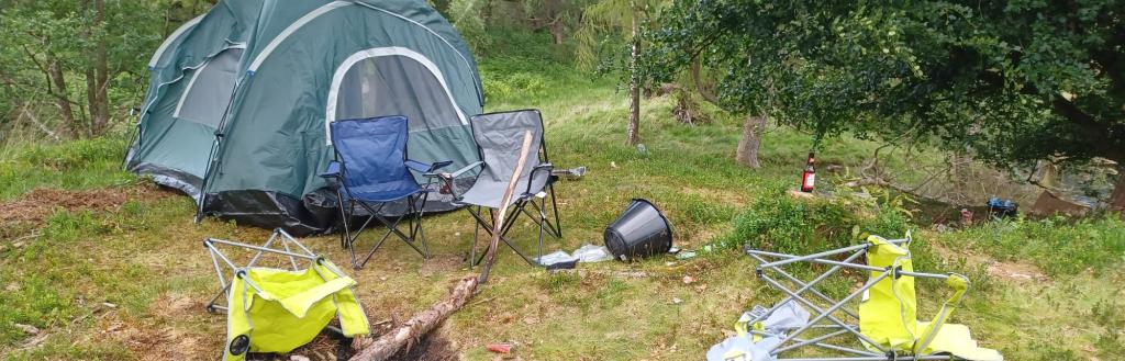 Fly camping, a camping fire using trees from the local area and rubbish left at a National Trust green space