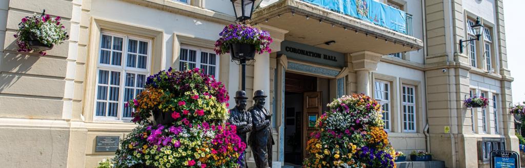 The Lauren and Hardy statue outside the Coro surrounding by bright flowers