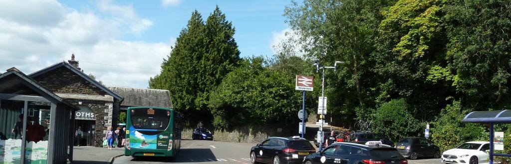 A bus at the bus stop and taxis at the taxi rank at Windermere train station.