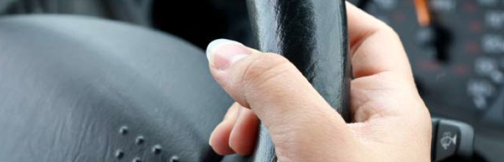 A hand holding the wheel of a car